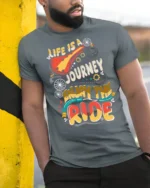Colorful Bicycle Quote Enjoy The Ride Adventure Graphic Tee - model wearing grey tee, leaning on column