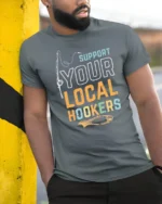Sarcastic Support Your Local Hookers Fishing Graphic Tshirt - model wearing grey tee, leaning on column