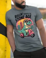 Sarcastic Dinosaur Riding Scooter Stone Age Graphic Tshirt - model wearing grey tee, leaning on column