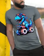 Patriotic Dinosaur Riding Monster Truck 4th Of July Tee - model wearing grey tee, leaning on column