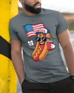 Festive USA Hot Dog American Flag Patriotic Graphic Tee - model wearing grey tee, leaning on column