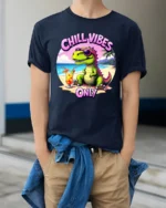 Hilarious Chill Vibes Only Dinosaur Beach Tropical Graphic Tee - model wearing navy tee with hands in pockets