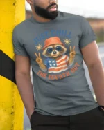 Funny Raccoon Just Chill The Fourth Out Independence Day Tee - model wearing grey tee, leaning on column