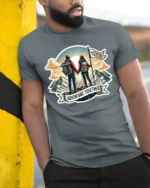 Adventure Together Couple Hiking Mountains Graphic Soft Tee - model wearing grey tee, leaning on column