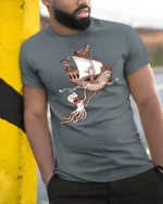 Funny Kraken Attack Pirate Ship Adventure Graphic Tshirt - model wearing grey tee, leaning on column