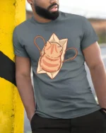 Cute Orange Tabby Cat in Paper Bag Graphic Tshirt - model wearing grey tee, leaning on column