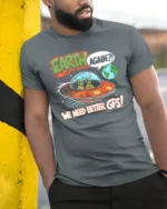 Funny Alien Earth Again We Need Better GPS Graphic Soft Tshirt - model wearing grey tee, leaning on column