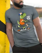 Cool Dinosaur T-Rex Riding Scooter Lets Go Soft Tshirt - model wearing grey tee, leaning on column