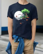 Cute Cat Fishing On Floating Island Full Moon Graphic Tee - model wearing navy tee with hands in pockets