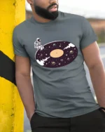 Surreal Astronaut Vinyl Record Space Galaxy Graphic Tshirt - model wearing grey tee, leaning on column