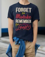 Forget The Mistake Remember The Lesson Graphic Tee - model wearing navy tee with hands in pockets