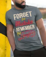 Forget The Mistake Remember The Lesson Graphic Tee - model wearing grey tee, leaning on column