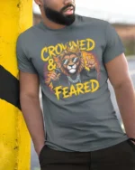 Crowned and Feared Lion Hip Hop Graphic Tee - model wearing grey tee, leaning on column