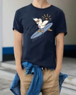 Catchy Salty Vibes Surfing Seagull Summer Graphic Tee - model wearing navy tee with hands in pockets
