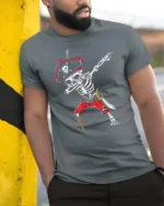 Funny Caribbean Dabbing Pirate Skeleton Graphic Tee - model wearing grey tee, leaning on column