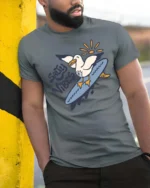 Catchy Salty Vibes Surfing Seagull Summer Graphic Tee - model wearing grey tee, leaning on column