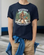 Funny Bigfoot Grabbed My Wiener Campfire Cookout Tshirt - model wearing navy tee with hands in pockets