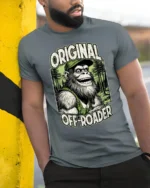 Funny Bigfoot Original Off Roader Trucker Hat Graphic Tee - model wearing grey tee, leaning on column