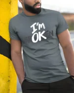 Cryptic Typographic Message Im OK Broken Statement Tshirt - model wearing grey tee, leaning on column