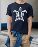 Aesthetic Surfboards Sea Turtle Tribal Line Art Graphic Tee - model wearing navy tee with hands in pockets