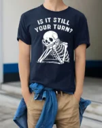 Relatable Is It Still Your Turn Board Game Skeleton Graphic Tee - model wearing navy tee with hands in pockets