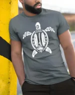 Aesthetic Surfboards Sea Turtle Tribal Line Art Graphic Tee - model wearing grey tee, leaning on column