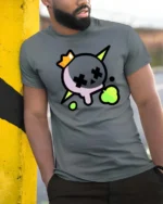 Striking Neon Skull Crown Cross Eyes Graphic Tee - model wearing grey tee, leaning on column