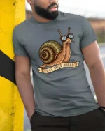 Amusing Full Speed Ahead Snail Sunglasses Graphic Tee - model wearing grey tee, leaning on column