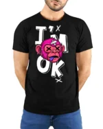 Gritty Pink Monkey Im Ok Broken Cartoon Graphic Tshirt - model wearing black tee with hands behind back
