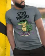 Cool Crocodile Wearing Sneakers Stay Weird Graphic Tee - model wearing grey tee, leaning on column