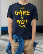 Ultimate The Game Is Not Over Yellow Typography Tshirt - model wearing navy tee with hands in pockets