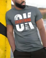 Motivating OK Everything Will Be OK Text Graphic Tshirt - model wearing grey tee, leaning on column