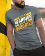 Motivating Be A Warrior Not A Worrier Workout Graphic Tee - model wearing grey tee, leaning on column